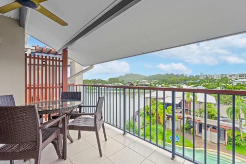 a balcony with a table and chairs and a view at Bluewater Haven - Sweeping Lagoon Views with Pool in Trinity Beach