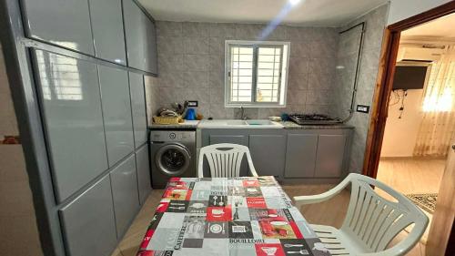 a small kitchen with a table and chairs and a sink at Marsa plage kelibia in Kelibia