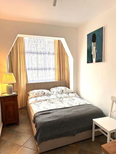 a bedroom with a bed and a window at Pottery Town Center Apartment in Bolesławiec