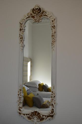 an ornate mirror in front of a bed with pillows at Edinburgh37 in Edinburgh