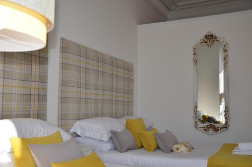 a living room with a white couch with yellow pillows at Edinburgh37 in Edinburgh