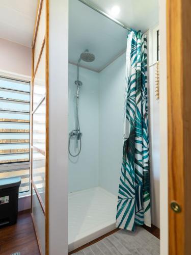 a shower in a bathroom with a shower curtain at Fare AGT Moorea in Afareaitu