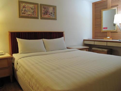a bedroom with a large bed and a window at 高第商旅 Gaudi Hotel in Kaohsiung