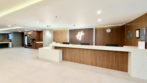 an office lobby with a reception counter and wooden walls at Holiday Inn Acapulco Amarea by IHG in Acapulco