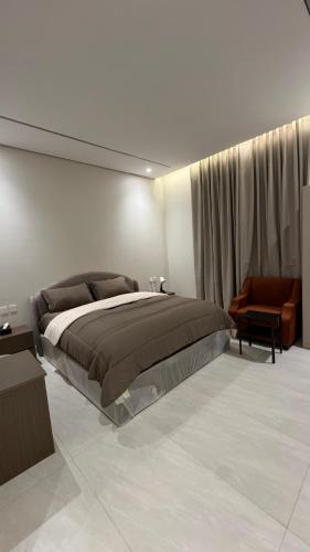 a bedroom with a large bed and a chair at سويت بغرفة نوم شوحط in Abha