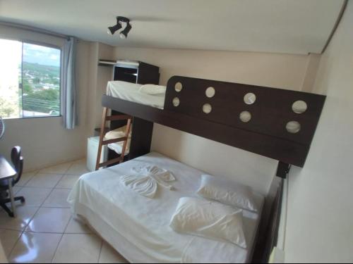 a small bedroom with two bunk beds and a window at Florença Hotel in Quedas do Iguacu