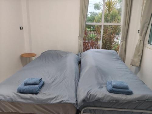 a bed in a room with two pillows on it at Small home in Ban Khlong Hok Wa