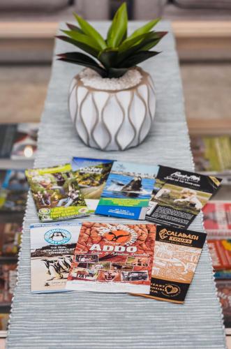 a table with magazines and a potted plant on it at Admirals Lodge Guest House and Brightways self catering apartments in Port Elizabeth