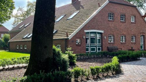 a brick house with a tree in front of it at Ferienwohnung Marita 35681 in Uplengen