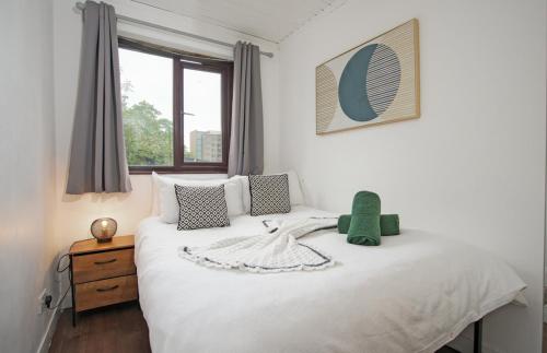 a bedroom with a large white bed with a window at BrightCentral Apartment With Parking in Glasgow