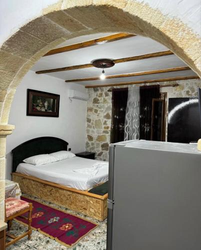 a bedroom with a bed and a refrigerator at Stone House in Vlorë