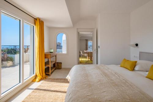 a bedroom with a large bed and a large window at Les Pins in Cannes