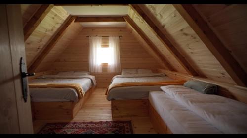 a attic room with four beds and a window at Melaya 1600 in Kolašin