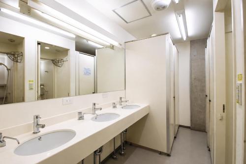 a bathroom with three sinks and a large mirror at Sakura Hostel Asakusa in Tokyo
