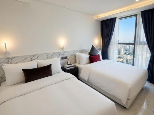two white beds in a hotel room with a window at HOTEL THE MAY Jongno in Seoul