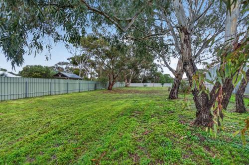 a yard with a fence and a tree at The Brynes Hideaway - On Brynes Road in Goolwa