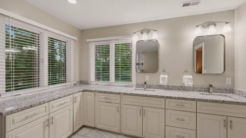 a white bathroom with two sinks and two mirrors at Poolside Paradise by AvantStay in Sherrills Ford