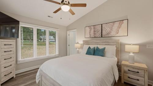 a bedroom with a white bed and a ceiling fan at Poolside Paradise by AvantStay in Sherrills Ford