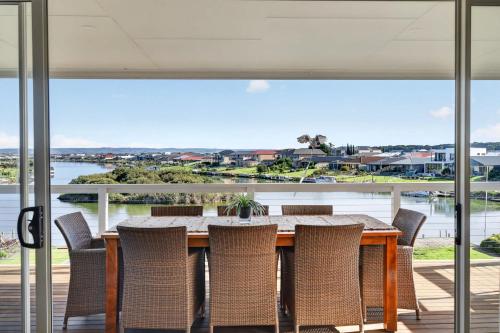 a dining room with a table and chairs and a large window at Marina Breeze - Excelsior Pde in Hindmarsh Island