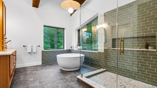 a bathroom with a tub and a glass shower at Bates Ridge by AvantStay in Tannersville