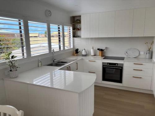 a kitchen with white cabinets and a white counter top at 2 Shore Ct - Shore Thing in Goolwa South