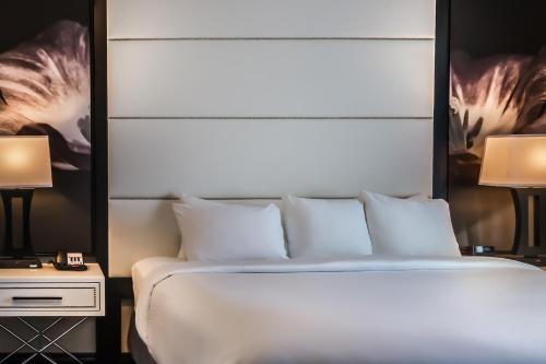 a bed with white sheets and pillows in a bedroom at TRYP by Wyndham Savannah in Savannah