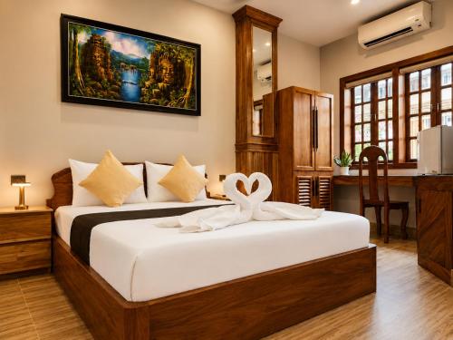 a bedroom with a bed with a ribbon on it at Dynasty Boutique Hotel in Phnom Penh