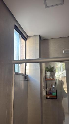 a sliding glass door in a room with a window at Studio lnhô Tim in Brumadinho