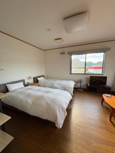 a bedroom with two beds and a window at はなれ香 in Kirishima