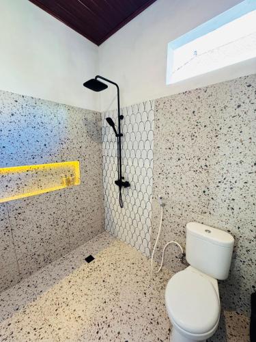 a bathroom with a white toilet and a window at Umanara Ubud in Ubud