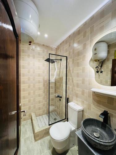 a bathroom with a toilet and a glass shower at House Pyramids View Hotel in Cairo