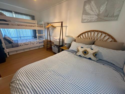 a bedroom with a bed with blue and white stripes at Flahertys Retreat in Point Turton