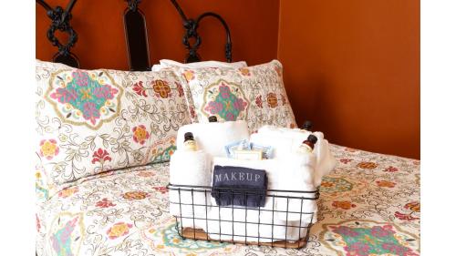 a basket of towels sitting on a bed with pillows at Zane Grey in Cimarron