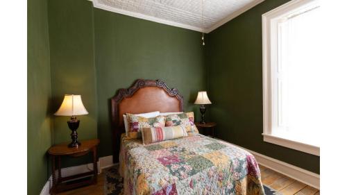 a green bedroom with a bed and a window at Remington in Cimarron