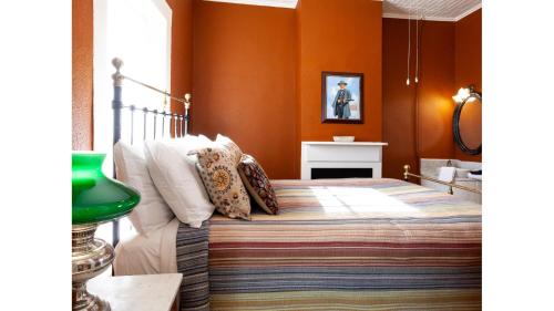 a bedroom with a bed with orange walls at Doc Holiday in Cimarron