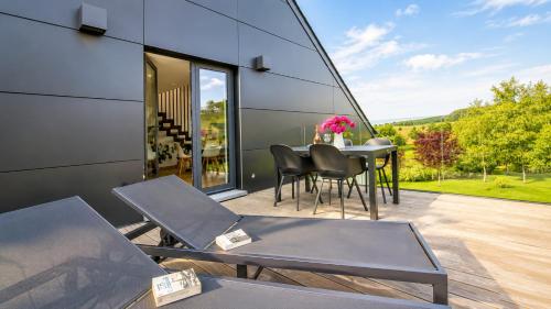 a glass house with a table and chairs on a patio at La Terrasse d'Arthur et Manon in La-Roche-en-Ardenne
