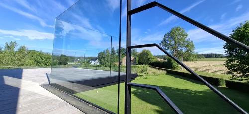 a glass house with a view of the yard at La Terrasse d'Arthur et Manon in La-Roche-en-Ardenne