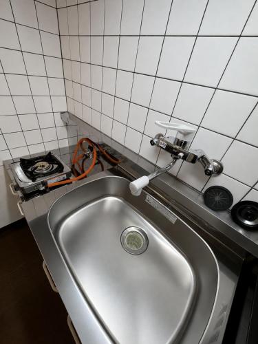 a kitchen sink with a faucet on a counter at Palette Kuhonji in Kumamoto