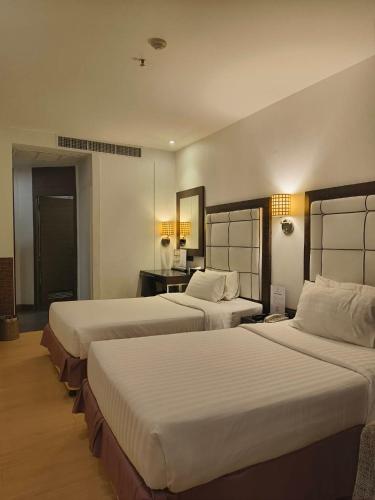 a hotel room with two beds in a room at Sukhumvit Suites Hotel in Bangkok