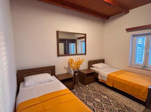 two beds in a room with a mirror at Casa del Mar Rooms in Lopud