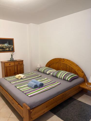 a bedroom with a wooden bed with a blue towel on it at Villa Maslina in Zadar