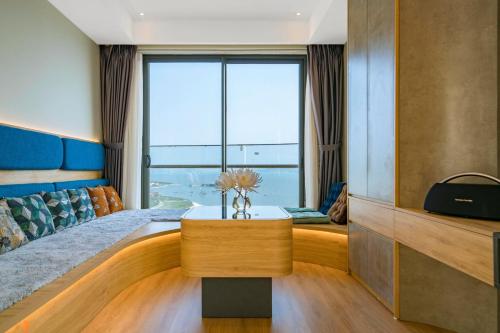 a living room with a bed and a large window at Homestay Alacarte - Icon40 - New Life - Villa Lotus in Ha Long