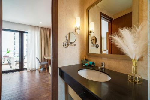 a bathroom with a sink and a large mirror at Homestay Alacarte - Icon40 - New Life - Villa Lotus in Ha Long