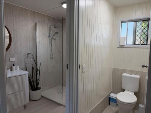 a bathroom with a shower and a toilet and a sink at Dunworkin Rainbow Beach in Rainbow Beach