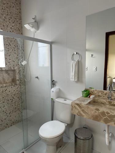 a white bathroom with a toilet and a shower at Hotel São Francisco in Piranhas