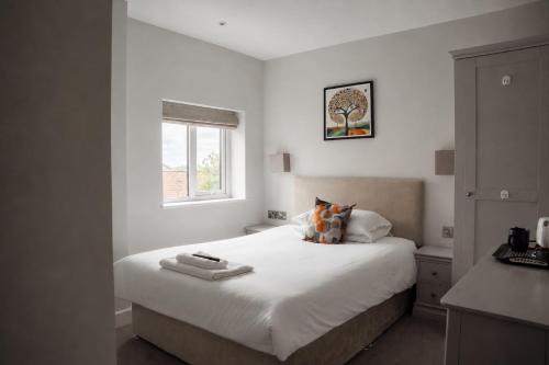 a bedroom with a bed with white sheets and a window at Salt Rooms in Scarborough