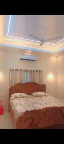 a bedroom with a bed with a ceiling fan at Relax Holiday Guest House in Kākināda