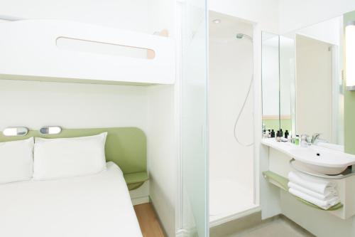 um quarto com uma cama, um lavatório e um espelho em ibis budget Hamburg St Pauli Messe em Hamburgo