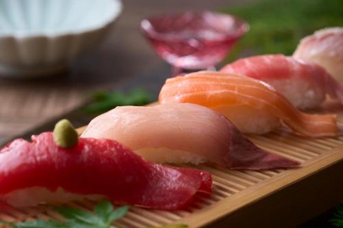 a pile of sushi on a wooden plate at Ooedo Onsen Monogatari Premium Kinugawa Kanko Hotel in Nikko