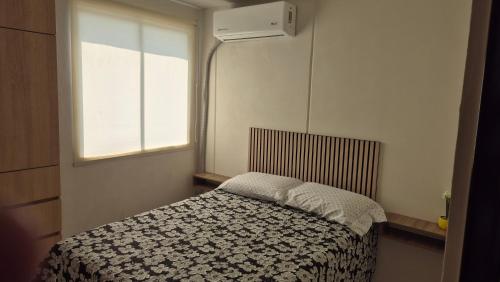 a small bedroom with a bed and a window at Your Perfect Rest Apartment with Pool and AC in Playa de Vacas